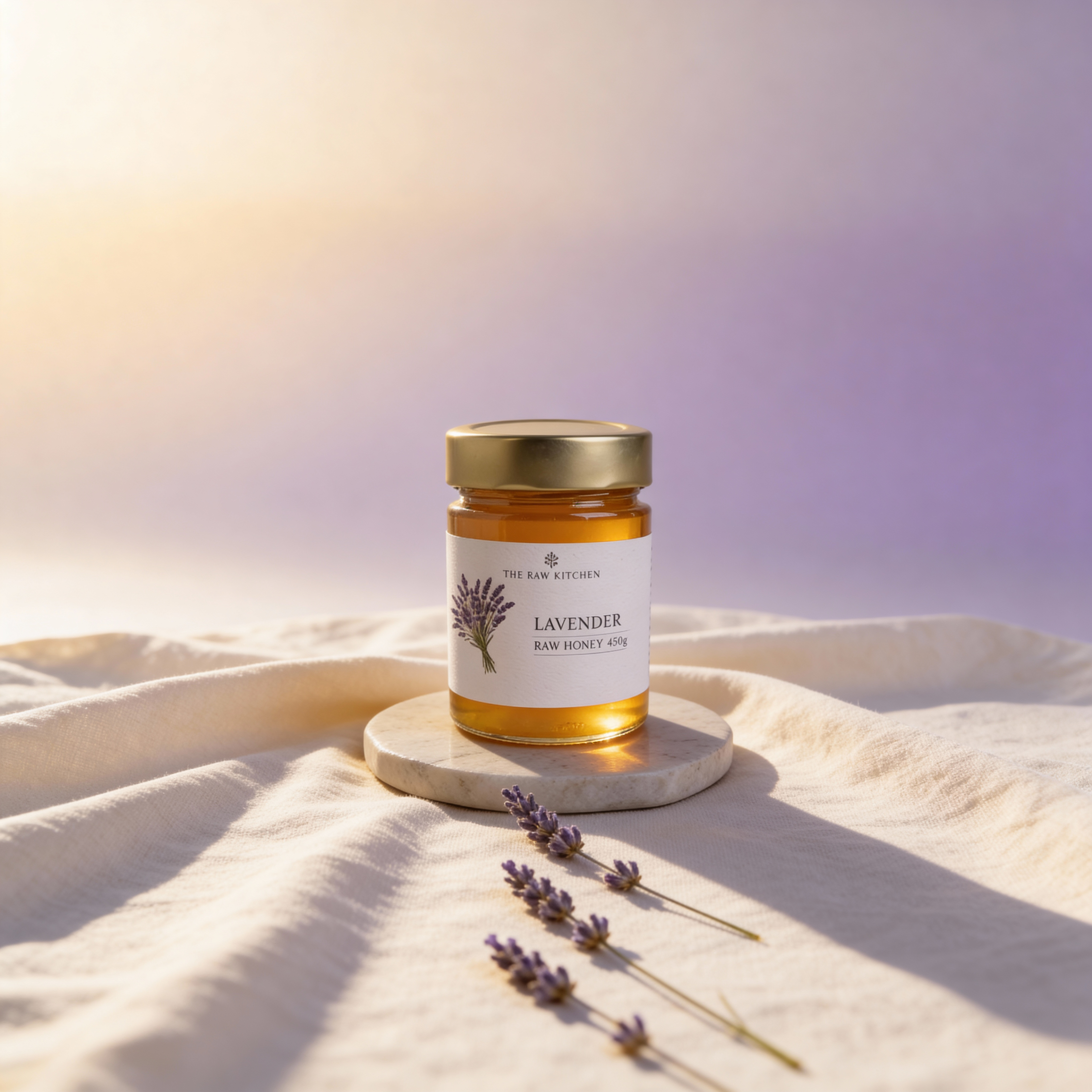 Jar of lavender honey on a light fabric background with lavender flowers.