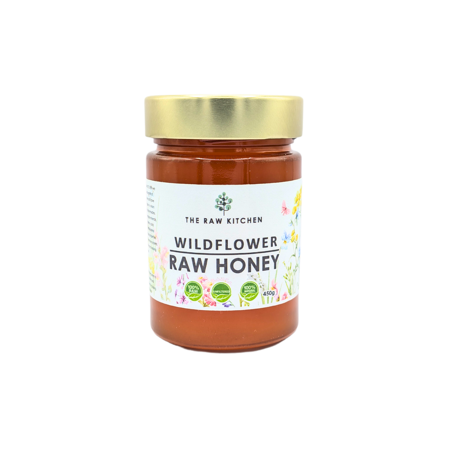A 450g glass jar of Wildflower Raw Honey with a gold lid and branded label - The Raw Kitchen UK.