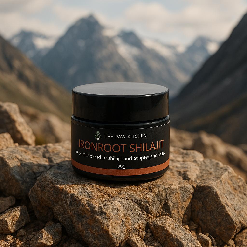 A jar of Ironroot Shilajit from The Raw Kitchen UK resting on a rock in a high-altitude mountain setting, highlighting its natural origins.