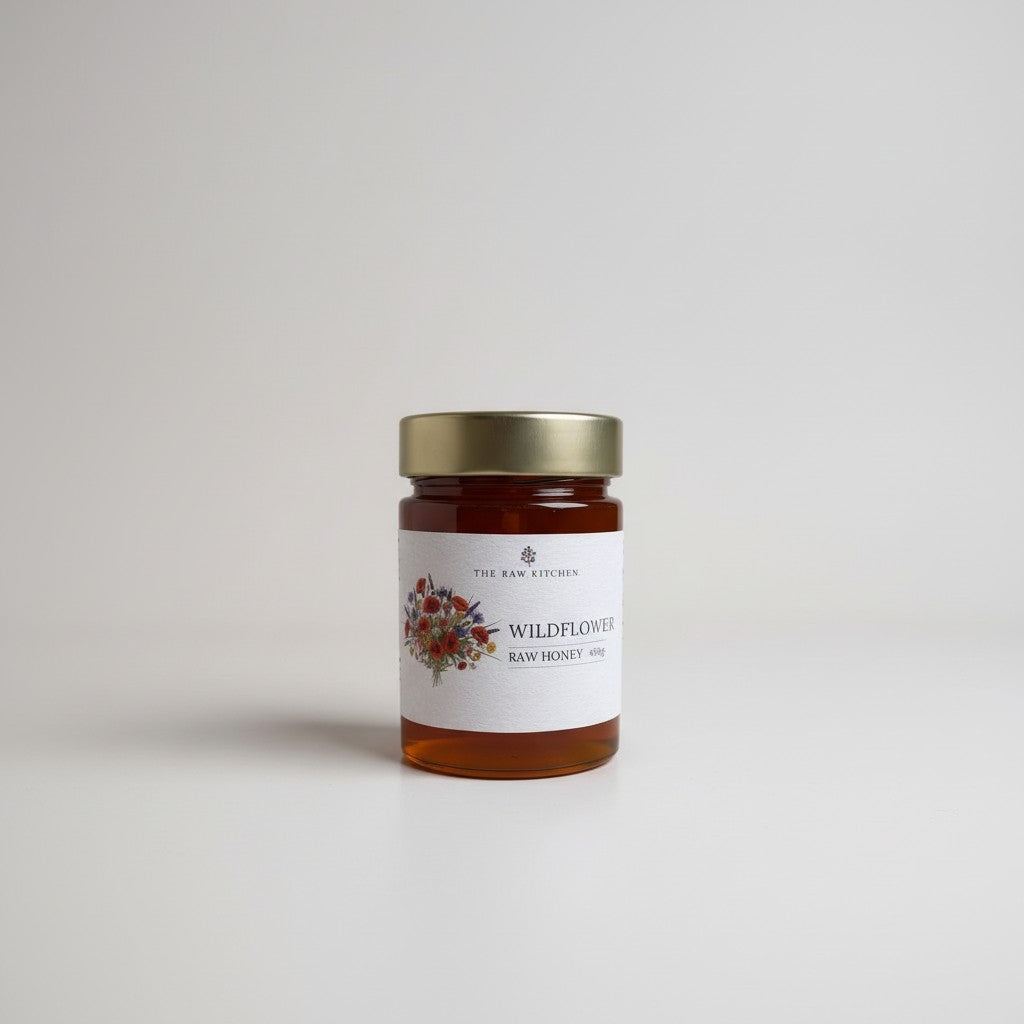 Jar of wildflower honey with a decorative label on a light gray background