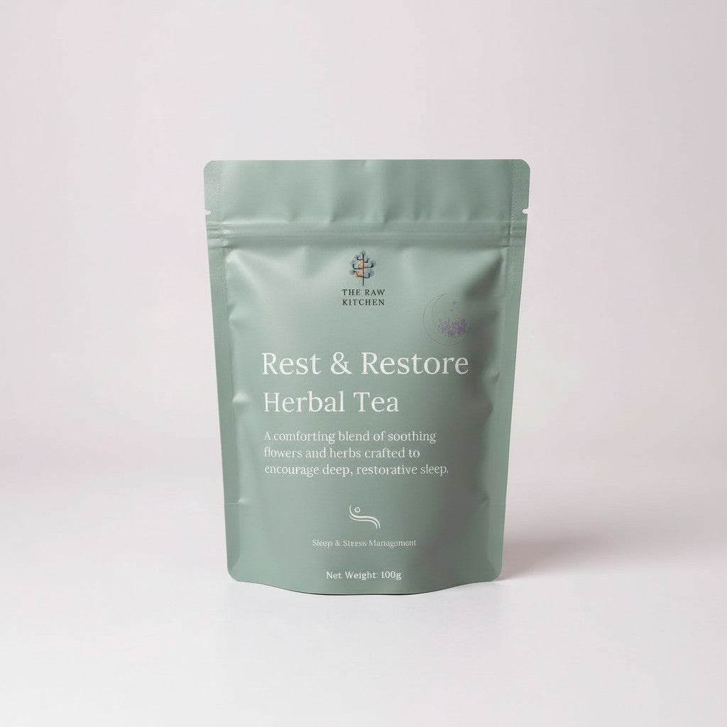 Green package of 'Rest & Restore Herbal Tea' from The Raw Kitchen on a light pink background