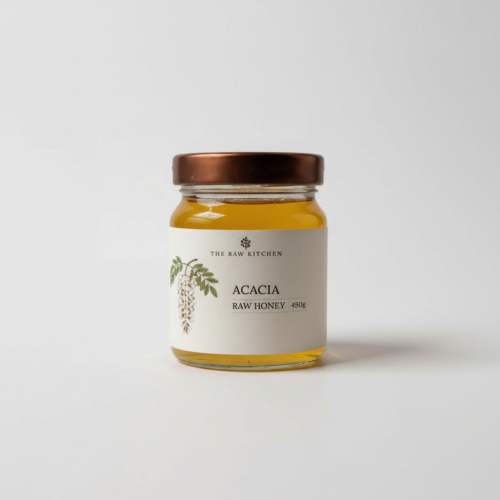 Jar of Acacia raw honey from The Raw Kitchen on a white background